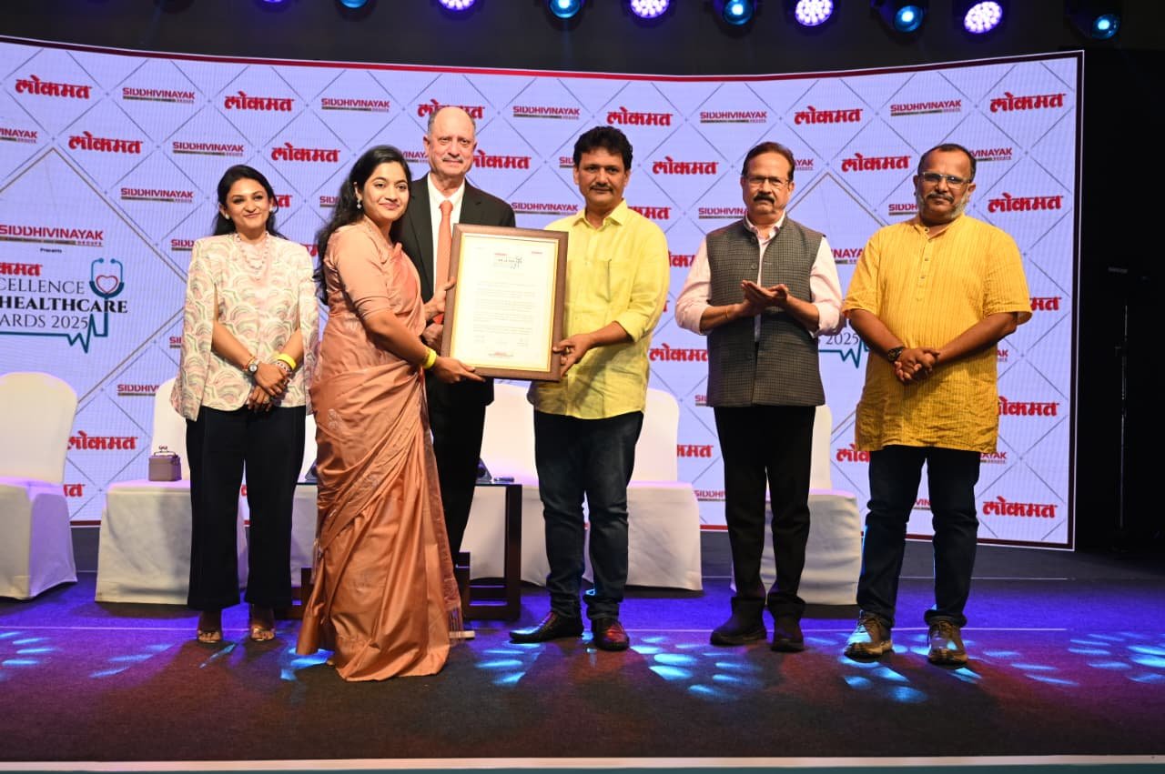 Dr. Kanchan Durugkar receiving a healthcare excellence award on stage at a prestigious medical awards ceremony in Pune.